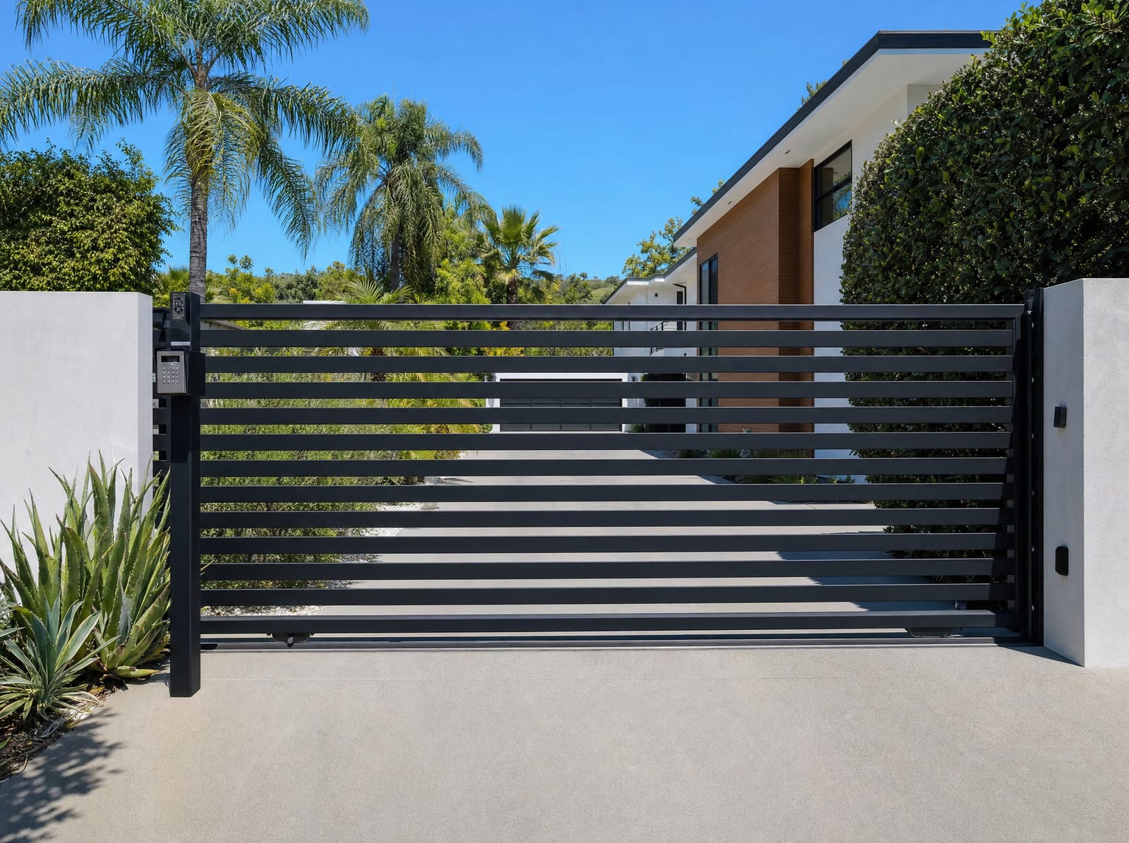 Automated black sliding driveway gate with keypad entry